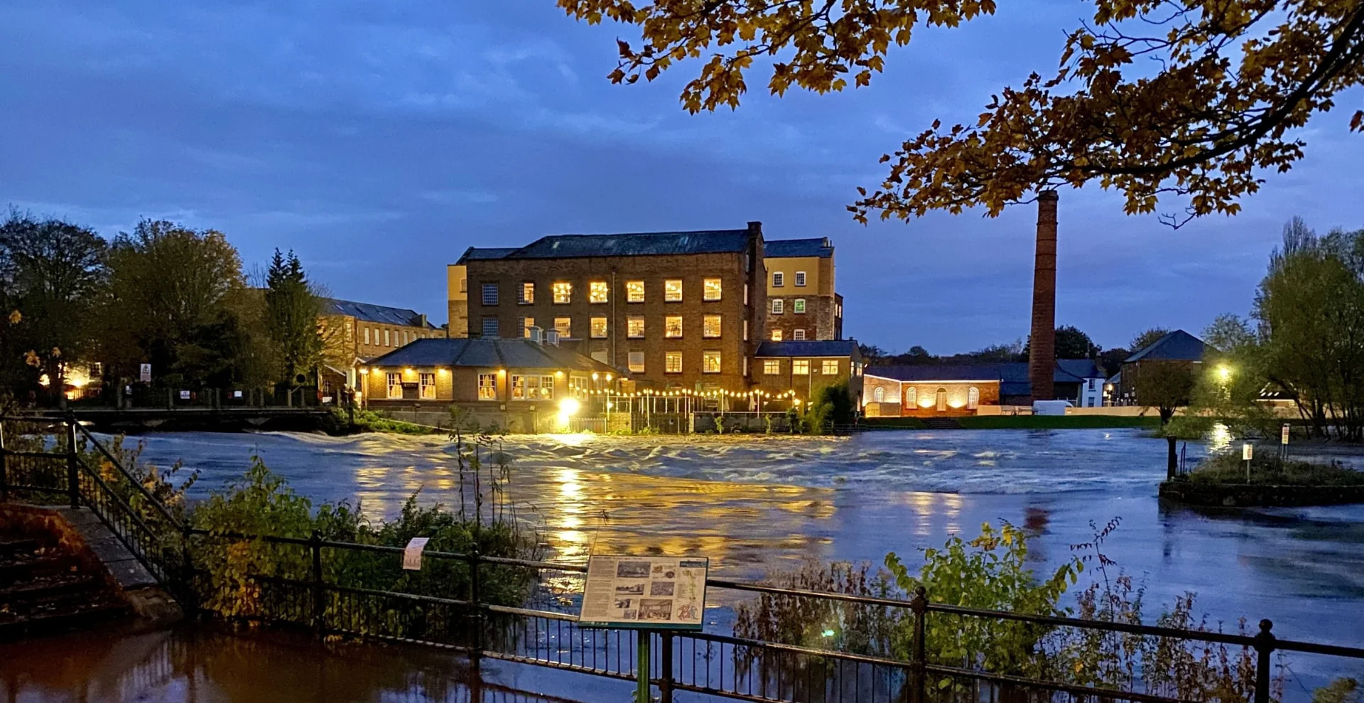 Darley Abbey Mills lit up at dusk above the River Derwent, home of The Brasserie at Darleys